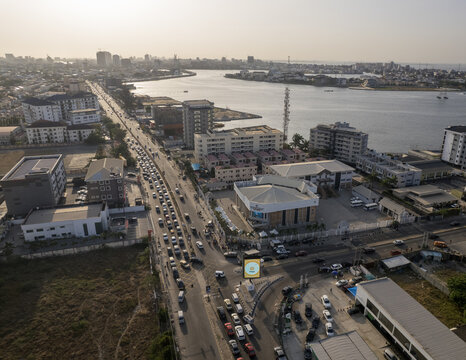 Aerial view of traffic congestion on a major road near the Five Cowries Creek, a vibrant mix of buildings and open spaces under a hazy sky, Lagos, Lagos, Nigeria.