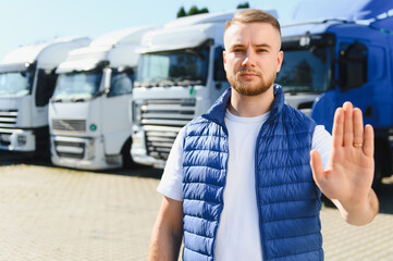 Fototapeta premium Truck driver making stop gesture in parking lot