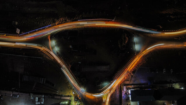 Aerial view of long exposure light trails painting vibrant streaks across the dark roads of Jahi, illuminating the night, Jahi, Federal Capital Territory, Nigeria.