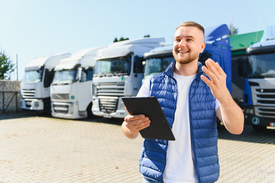 Truck driver smiling using tablet managing logistics fleet
