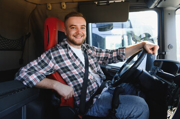 Male truck driver smiling in semi truck cabin