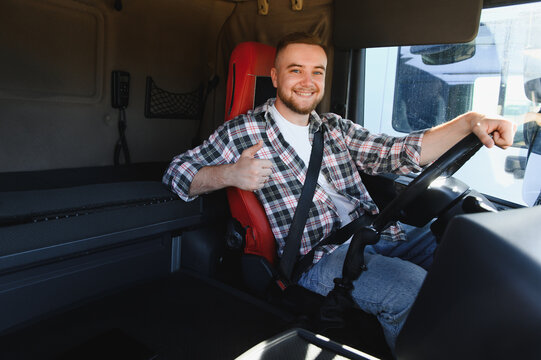 Truck driver smiling giving thumbs up in cabin