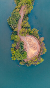 Aerial view of a winding path and open circle on a small island surrounded by still, blue waters, Alex Ekwueme Way, Abuja, Federal Capital Territory, Nigeria.