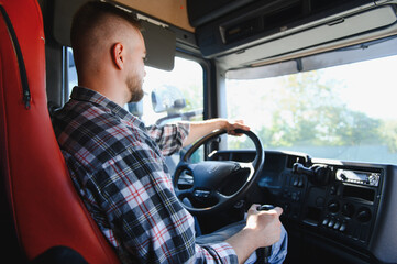 Obraz premium Truck driver steering vehicle in semi cabin