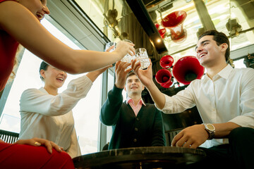 Cheers to success A group of diverse businessmen celebrate a new deal with a joyful toast at a modern bar, symbolizing teamwork and achievement.