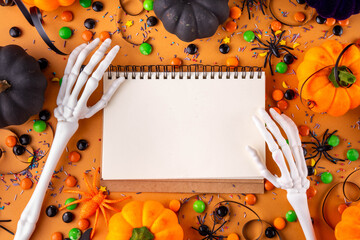 Bright colorful Halloween party accessories and decor background, treat or trick holiday with colorful candies, traditional Halloween sweets, pumpkins and decorations top view copy space