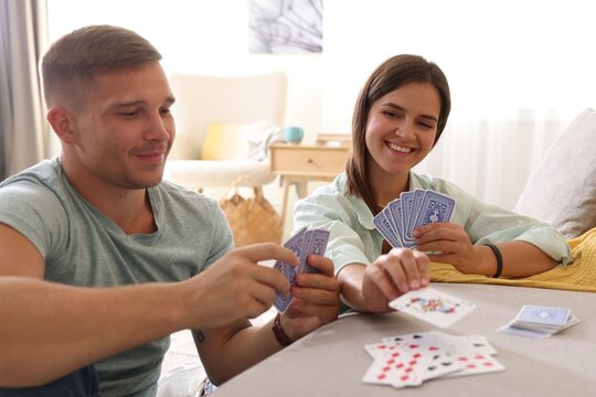 Man and woman playing cards at home - Powered by Adobe