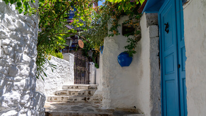 Narrow street with stairs with blue door and green plants in old town of Marmaris, Turkey. Beautiful historical part of city. Travel, journey and adventure in beautiful place