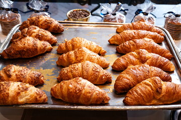 Freshly made French croissants on a silver tray. Top down, close up view, no people