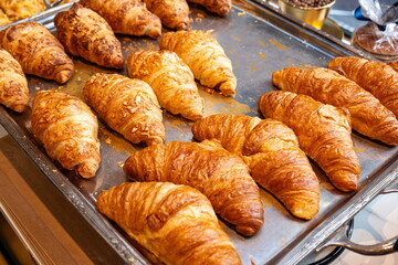 Freshly made French croissants on a silver tray. Top down, close up view, no people