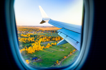 Airplane wing over green fields at sunrise in Copenhagen, Denmark. Scandinavian landscapes seen from above.   © Tomasz