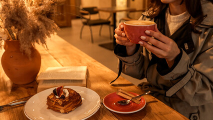 Girl enjoying coffee and pastry in a cozy cafe setting