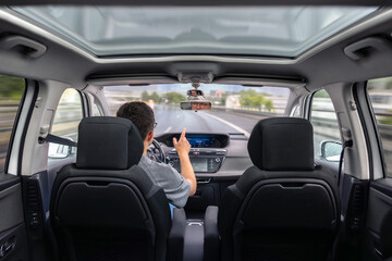 Driver pointing hand while driving. Dynamic motion on highway.