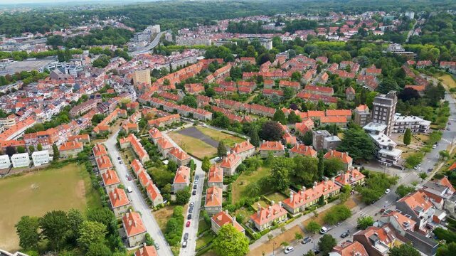 Aerial view of rows of houses with red roofs contrasting with the lush green trees along 1 Avenue des Nymphes, Watermael-Boitsfort, Bruxelles, Belgium.