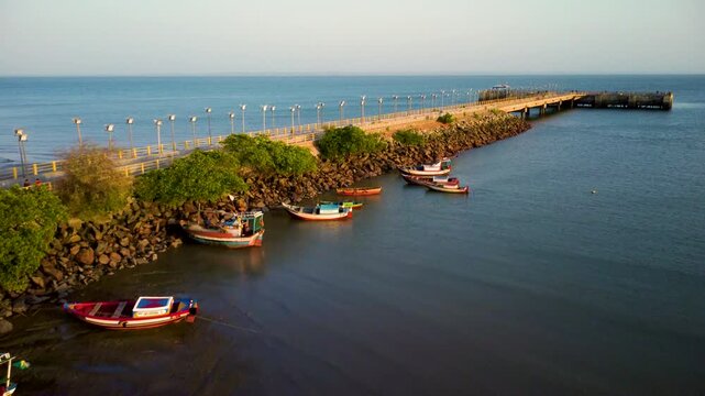Cinematic aerial drone view moving along the pier in S&atilde;o Jos&eacute; de Ribamar during golden sunset