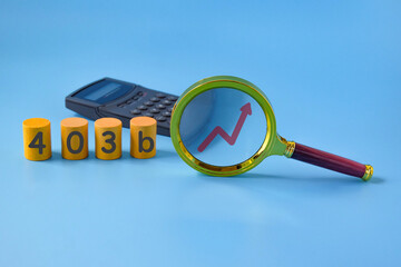 Business concept meaning 403b,Magnifier glass with calculator.