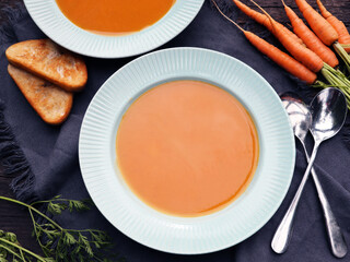 Carrot cream soup on rustic wooden table. Autumn  cream soup with croutons. Top view.