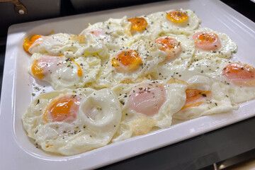 Delicious fried eggs at a self service breakfast buffet. Close up.