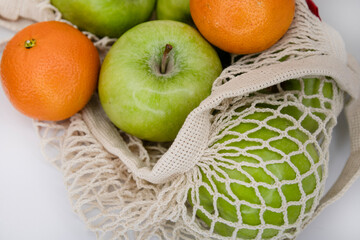 Eco Mesh Bag with Green Apples and Fresh Tangerines on White Background – Organic Fruit Flat Lay