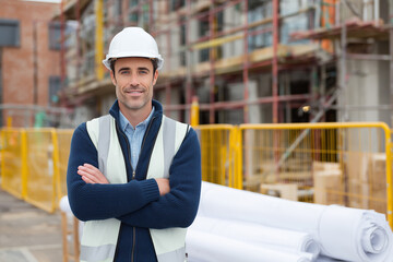 Young engineers and construction workers wear safety helmets for work on an industrial building site