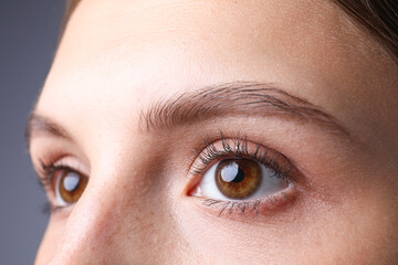 Fototapeta premium Woman with beautiful eyes on grey background, closeup