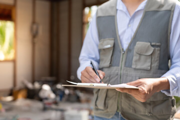 inspector or engineer is inspecting construction and quality assurance new house using a checklist. Engineers or architects or contactor work to build the house before handing it over to the homeowner