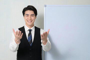 ホワイトボードの前でプレゼンをする日本人男性