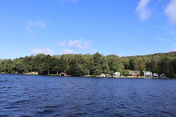 A view of Canada lake's shoreline with docks and lake houses in the summer.