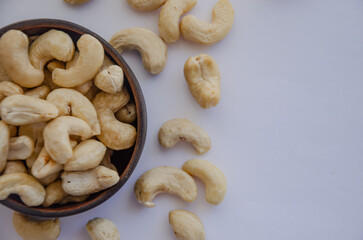 cashew nuts in a wooden round bowl on a light background