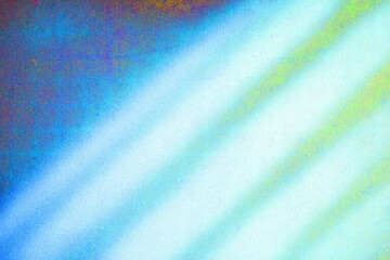 Colorful bands of light cast diagonally across a textured surface. The hues transition from deep blue to bright yellow, creating a vibrant display.AI generated.