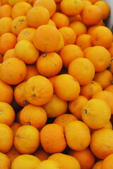 Fresh oranges displayed at local market. Organic citrus fruits rich in vitamin C, healthy natural food background, concept of vegan nutrition, freshness, and tropical harvest.