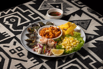 Peruvian ceviche served with grilled shells, fried cassava, fried octopus, and fresh sweet corn salad