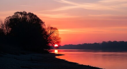 Tranquil river scene at sunset with trees and colorful sky