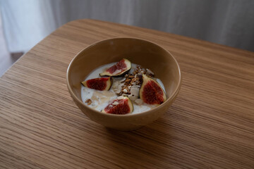 A beautifully arranged yogurt bowl decorated with figs and crunchy granola, which is perfect for a delicious breakfast.