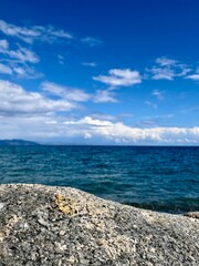 Fels und Meer mit blauem Wasser und klarem Himmel