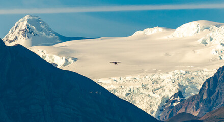 Small plane flying over glacier in Wrangell Mountains, Alaska.
