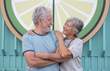 Lovely senior couple hugging smiling standing in outdoors looking at each other happily expressing love and emotions. Youthful couple enjoying retirement lifestyle