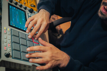 Beatmaker in a studio producing some music with an Akai MPC LIVE II