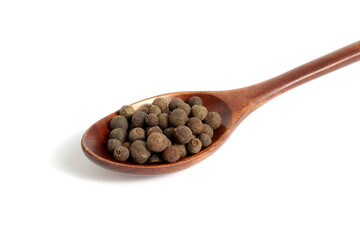 On a white background lies a pile of allspice peas.	