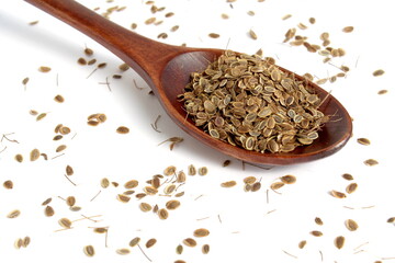 There is a pile of dill seeds on a wooden spoon.	