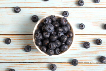 There is a bowl of ripe blueberries on the table.	