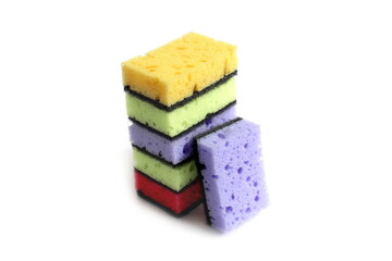 Many bright multi-colored sponges for washing dishes lie on a white background.	