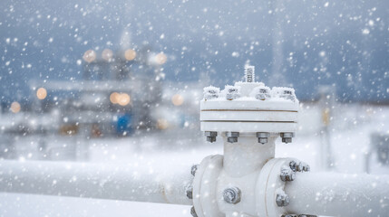 Close-up of gas pipeline joint covered in snow, ice crystals on bolts and flanges, winter industrial environment