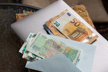 Bulgarian Lev and 50 Euro notes on silver laptop, depicting Bulgaria's Lev to Euro currency change....
