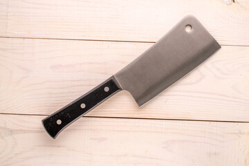 Kitchen knife on a wooden table, close-up, top view.