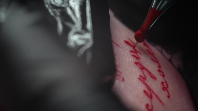Tattoo machine close up is making paint. Red ink color needle. Extreme macro slow motion