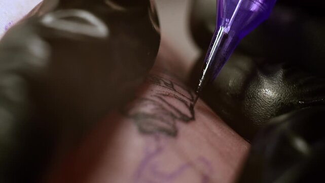 Tattoo machine close up is making paint. Black ink color needle. Extreme macro slow motion