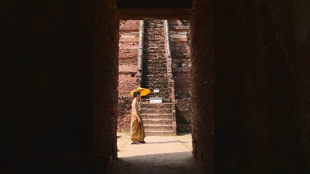 Thailand, Ayutthaya - march 15th, 2023: Woman in traditional Thai dress pose sightseeing visit ancient Buddha statue.Ayutthaya historical park. UNESCO World Heritage Site