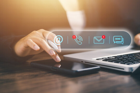 A woman using smartphone and laptop with contact icons floating above, representing customer communication, digital contact center, online service, and omnichannel business interaction.