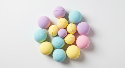 Obraz premium Collection of colorful pastel bath bombs on white background. Top view flat lay of spa products for self-care and relaxation. Natural cosmetics concept with copy space